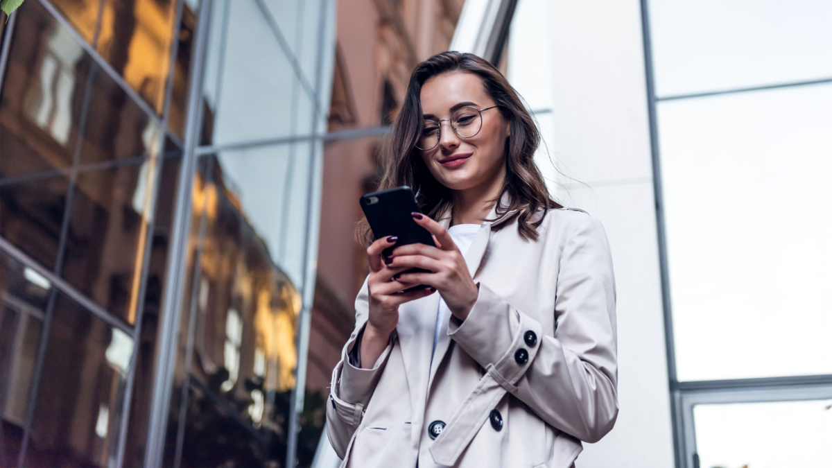 Frau mit Brille schaut auf ihr Smartphone