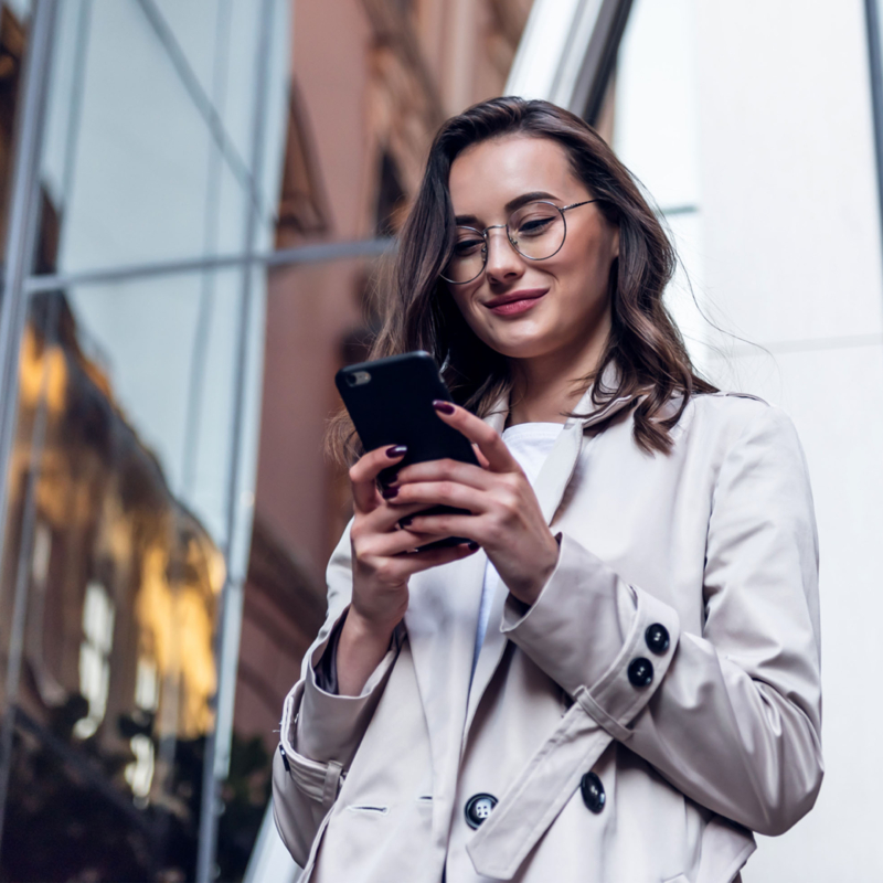 Frau mit Brille schaut auf ihr Smartphone