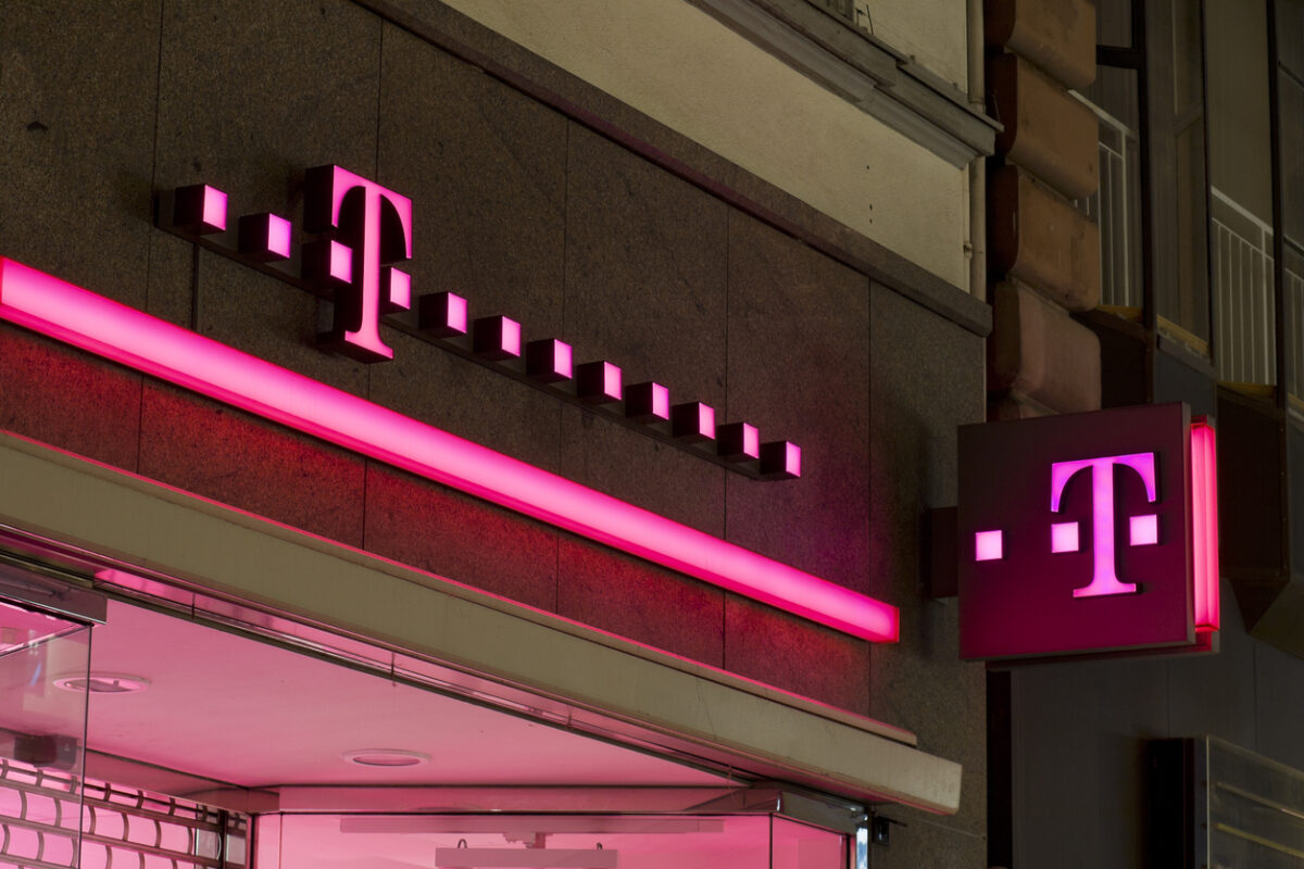 Telekom Logo leuchtet an Hauswand