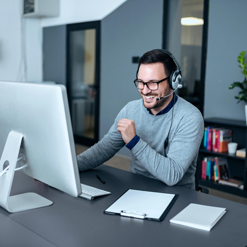 Mann in grauem Pulli vor Laptop