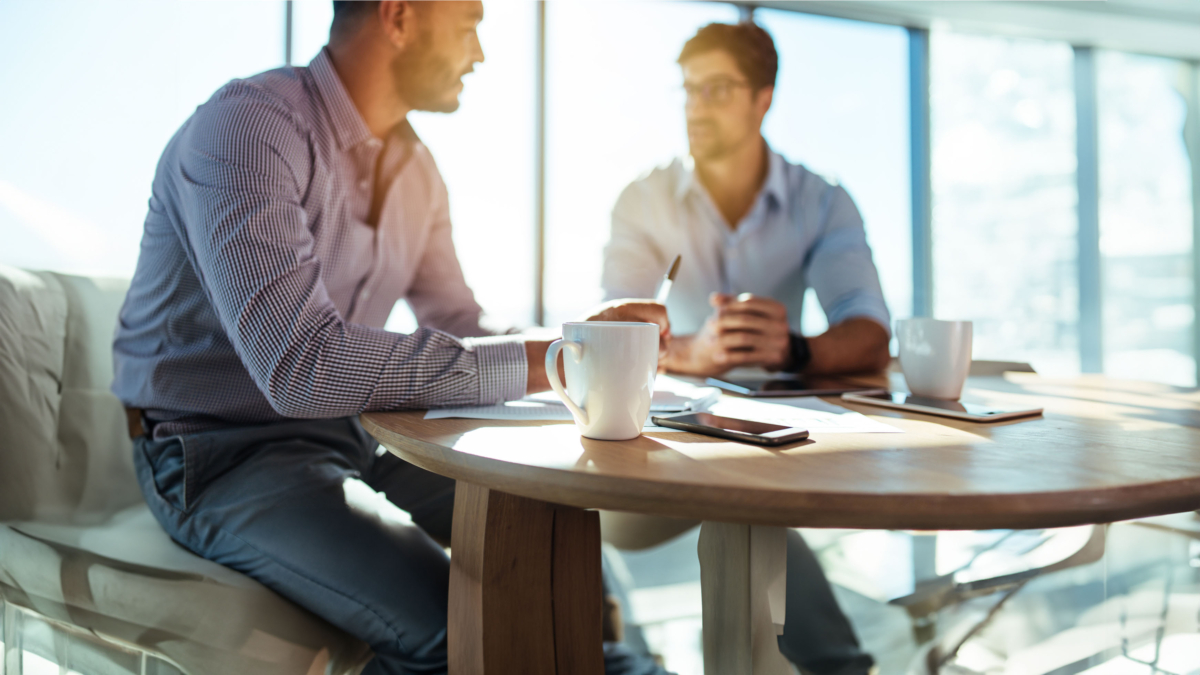 Zwei Männer mit Kaffeetasse beim small talk