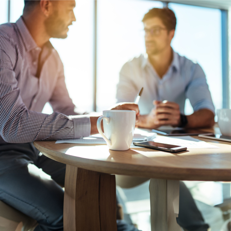 Zwei Männer mit Kaffeetasse beim small talk